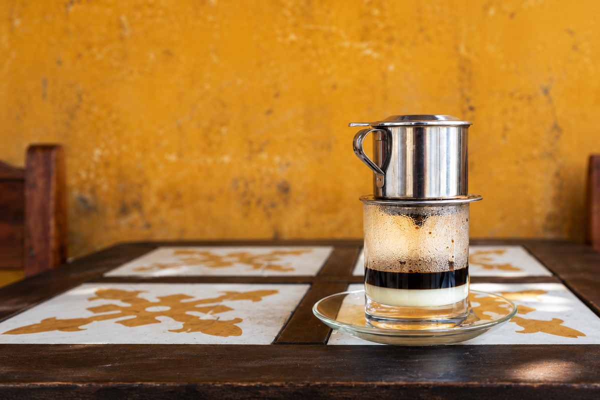 Vietnamese phin filter dripping coffee into a glass