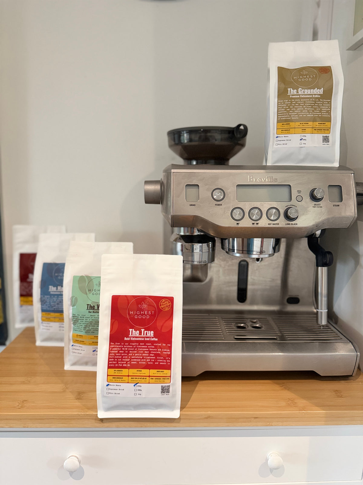Highest Good coffee bags beside a home espresso machine
