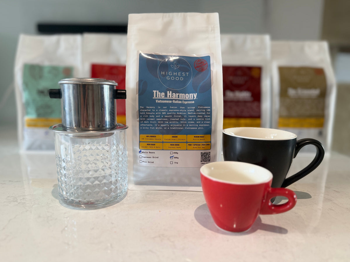 Highest Good The Harmony coffee bag in front of the Highest Good range, with a phin filter and cups