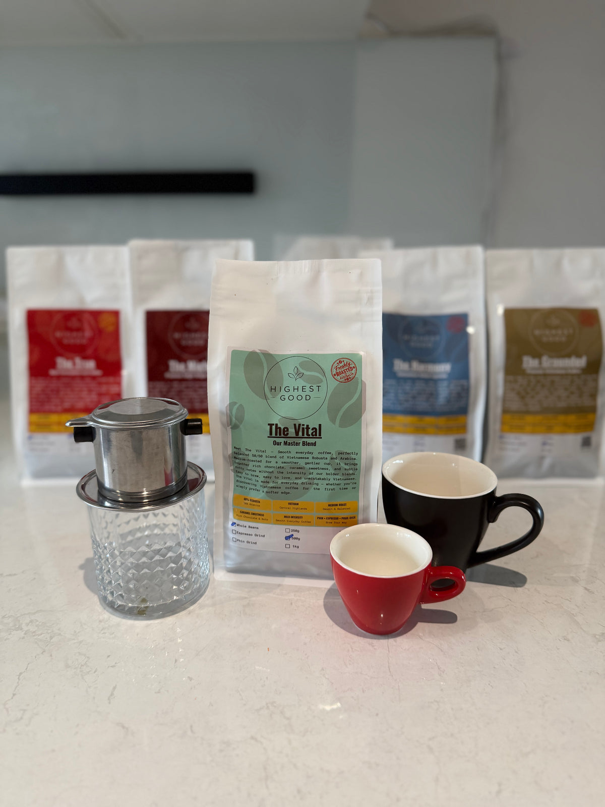 Highest Good The Vital master blend coffee bag in front of the Highest Good range with a phin filter