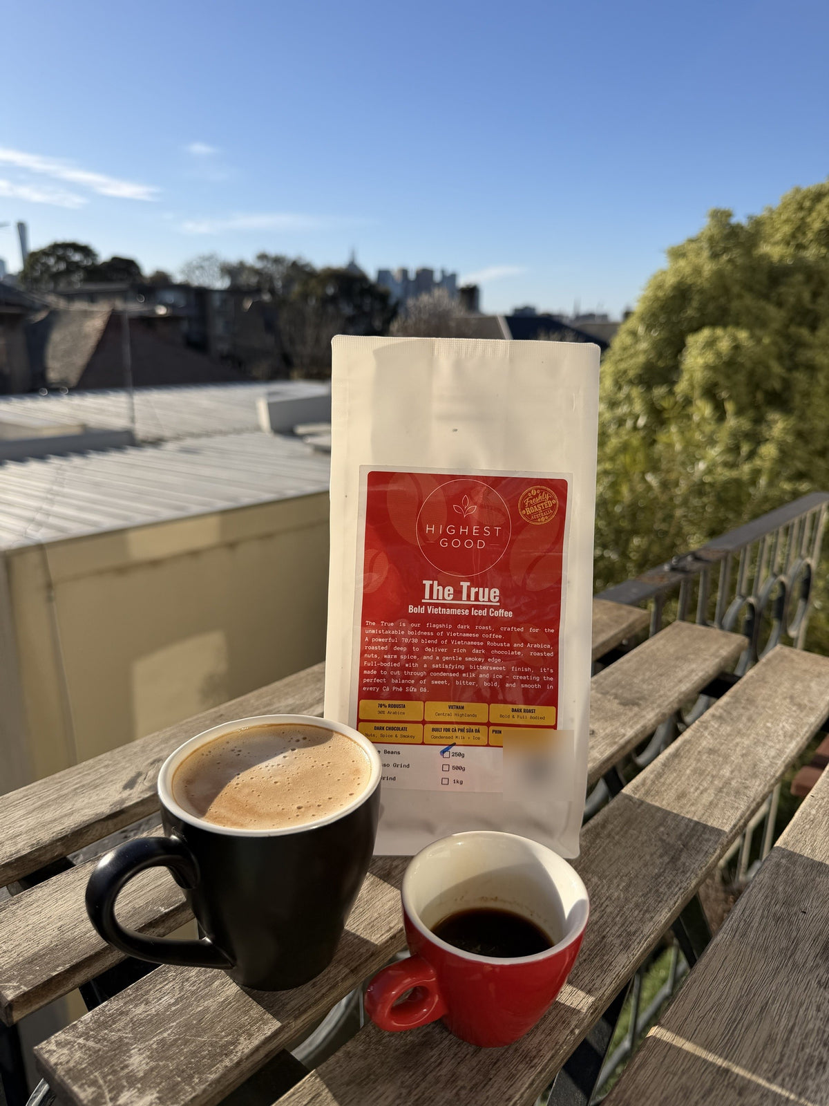 Highest Good The True dark roast Vietnamese coffee beans with a latte and espresso on a sunny Melbourne balcony